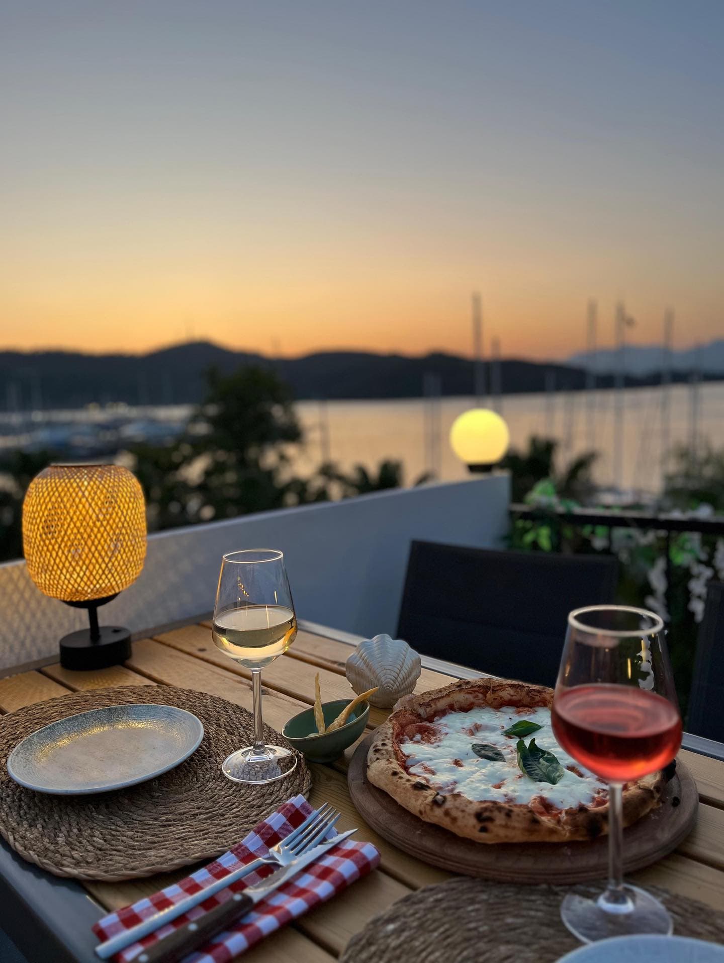 Gün batımında terasta margherita pizza ve şarap